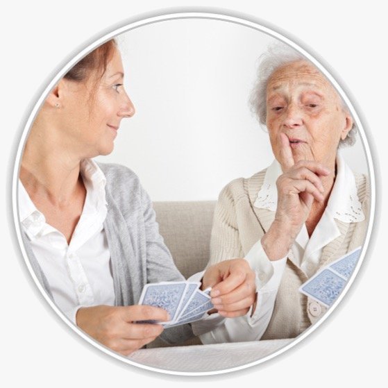 Eine junge Frau spielt Karten mit einer Seniorin
